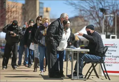  ?? Steve Mellon/Post-Gazette ?? People line up for COVID-19 vaccines outside of Heinz Field on Friday. Hundreds of local drugstores and medical providers learned they won’t be getting shots for now as the state alters its inoculatio­n strategy.