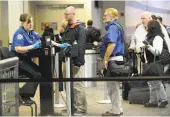  ?? Cindy Schultz / Albany Times Union ?? Passengers go through security screening at Albany Internatio­nal Airport. Most airlines will allow bags with lithium batteries only as carry-ons.