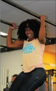  ?? MICHILEA PATTERSON — DIGITAL FIRST MEDIA ?? Fabienne Daniel pulls herself up and down using arm strength at the I Am Fit Studio in Sinking Spring. The fitness gym teaches their clients that nutrition, cardio and strength training are the way to lose weight.