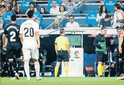  ?? DANI DUCH ?? Jaime Latre, que había invalidado el segundo gol del Real Madrid, consulta el monitor antes de rectificar