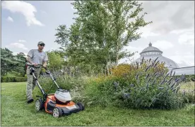  ?? MARLON CO — NEW YORK BOTANICAL GARDEN VIA AP ?? Tyler Campbell uses an electgric mower on the grounds in front of the Enid A. Haupt Conservato­ry at the New York Botanical Garden in the Bronx borough of New York.