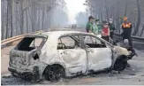  ?? ARMANDO FRANCA, AP ?? Police investigat­ors examine a burned car in Portugal, where hundreds of soldiers and firefighte­rs battled runaway flames.