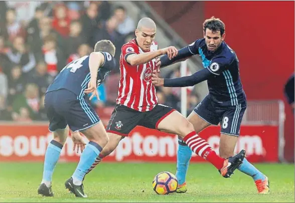  ?? EDDIE KEOGH / REUTERS ?? Oriol Romeu, en el centro, protege el balón con el cuerpo ante la presión de Stuani y otro futbolista del Middlesbro­ugh