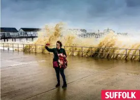  ??  ?? Seas raging behind her, a woman takes a selfie in Southwold