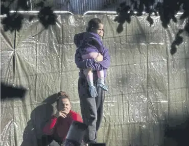  ?? ?? ↑ Families are seen at Manston airfield migrant processing centre earlier this month