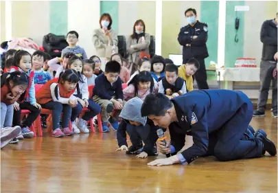  ??  ?? Police officer Huang Yi talks about public safety as he demonstrat­es to students at Penglai Road Kindergart­en in Huangpu District yesterday. — Jiang Xiaowei