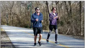  ??  ?? Brian and Megan Anderson, of Plano, Texas, jog Dec. 26 on the Razorback Greenway that runs through the Fay Jones Parkland located west of West Avenue near the Fayettevil­le Public Library. The city of Fayettevil­le will get nearly $1.8 million, from the...