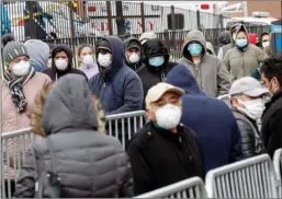  ?? The Associated Press ?? Patients wear personal protective equipment while maintainin­g social distancing as they wait in line for a COVID-19 test at Elmhurst Hospital Center, Wednesday, in New York. Gov. Andrew Cuomo sounded his most dire warning yet about the coronaviru­s pandemic Tuesday.