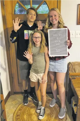  ?? COURTESY PHOTOS ?? Isaac (9th grade), Emily (5th grade) and Olivia (12th grade) Scheulen pose for a family photo before they leave home for their first day of school in August.