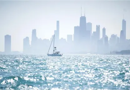  ?? PAT NABONG/SUN-TIMES FILE ?? A boat floats on Lake Michigan near Montrose Beach with the Chicago skyline in the background.