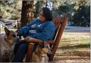  ?? DAI SUGANO — STAFF PHOTOGRAPH­ER ?? Evacuee Lorraine Martinez, of Windsor, sits with her dogs, Archer, left, and Brownie, at the KOA campground in Petaluma on Tuesday.