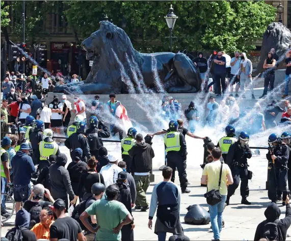  ??  ?? FLASHPOINT: A firework explodes in the middle of Trafalgar Square as police try to keep anti-racist and Far-Right protestors apart during yesterday’s marches