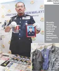  ?? AMIRUL SYAFIQ/ THESUN ?? Mustafar showing some of the items and uniforms (below) seized from the suspect’s house.