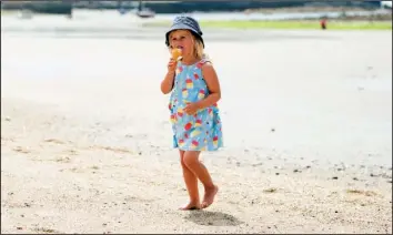  ?? VisitEngla­nd/ADAM GIBBARD ?? A little girl enjoys an ice cream cone as she plays on the sandy beaches in Cornwall.