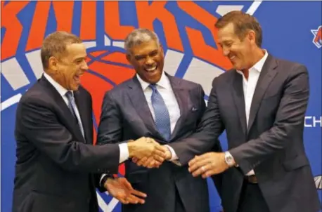  ?? THE ASSOCIATED PRESS ?? Knicks general manager Scott Perry, left, shakes hands with head coach Jeff Hornacek, right, while posing for a picture along with new president Steve Mills, during a Monday news conference.