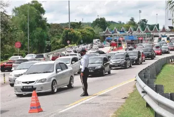  ?? — Bernama photo ?? A traffic policeman monitors the flow of vehicles heading towards Melaka.