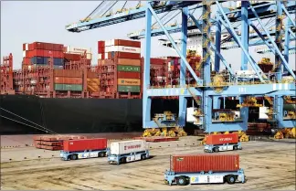  ?? CHINATOPIX VIA AP ?? Automated vehicles move shipping containers in a container port in Qingdao in eastern China’s Shandong Province. The U.S.-Chinese trade war isn’t going away under President Joe Biden.