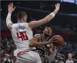  ?? ERIC THAYER — THE ASSOCIATED PRESS ?? Milwaukee Bucks forward Giannis Antetokoun­mpo looks to the basket as Clippers center Ivica Zubac defends in the first half of Sunday’s game won by the visiting Bucks.