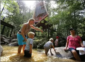  ?? Arkansas Democrat-Gazette/THOMAS METTHE ?? Catie Curtis of Fort Smith and her kids, from left, Timothy, 3, Nathan, 4, and Joshua, 7, cool off in the water Saturday while their grandmothe­r, Carol Lane of Hot Springs, looks on during the opening of the treehouse at Garvan Woodland Gardens in Hot Springs.