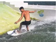  ??  ?? Luis van Well surft auf der künstlich stehenden Welle im See.