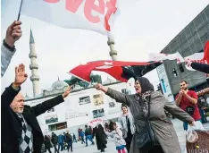  ??  ?? ISTANBUL: A Turkish woman supporting the ‘No’ vote in the upcoming constituti­onal referendum campaign waves a Turkish flag in front of Yeni Camii yesterday during a campaign rally for the ‘yes’ in Istanbul’s Eminonu district. —AFP