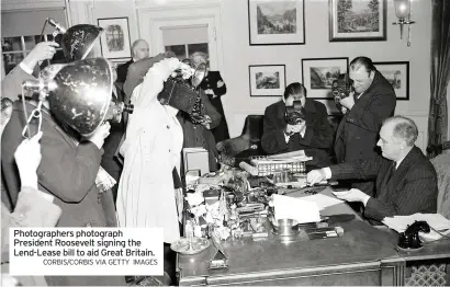  ?? CORBIS/CORBIS VIA GETTY IMAGES ?? Photograph­ers photograph President Roosevelt signing the Lend-lease bill to aid Great Britain.