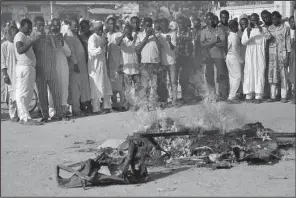  ?? AP/MUHAMMED GIGINYU ?? People gather at the site where multiple bombs went off Friday near a mosque in the Nigerian city of Kano. Witnesses said worshipper­s also were fired on.