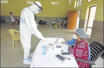  ?? PARVEEN KUMAR/HT ?? Health workers at a Covid-19 test registrati­on desk at a community centre in Gurugram on Tuesday.