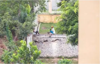  ?? PPEDRO BAZIL ?? Dos jóvenes y un estudiante descansan sobre el muro de la escuela Muñoz Soriano.