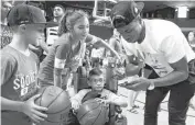  ?? [PHOTO BY STEVE SISNEY, THE OKLAHOMAN] ?? Former OU star Buddy Hield signs autographs for Pierson Aduddell, and brother and sister Brooke and Jeffrey Wright following Saturday’s OU’s Alumni Game at Lloyd Noble Center.