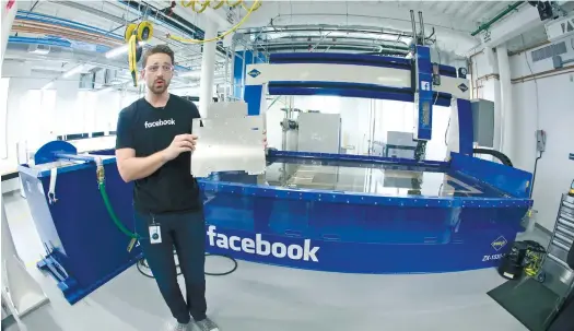  ?? (AP FOTO) ?? ROOM FOR ERROR. Model maker Spencer Burns holds up a piece of sheet metal while standing in front of a water jet during a tour of Area 404, the hardware R&D lab at Facebook headquarte­rs in Menlo Park, California.