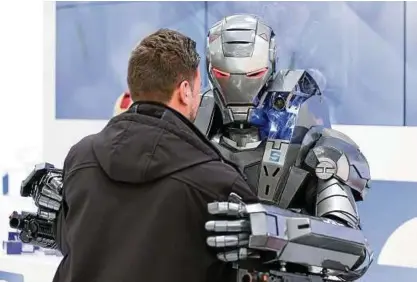  ??  ?? Ein „Ironman“-Roboter von Magnetbau Schramme umarmt einen Messebesuc­her. Foto: dpa/Friso Gentsch