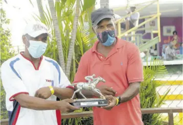  ?? (Photos: Garfield Robinson) ?? Trainer Michael Marlowe (right) receives the Henry Harrison Sr Memorial Trophy from Henry Harrison Jr.