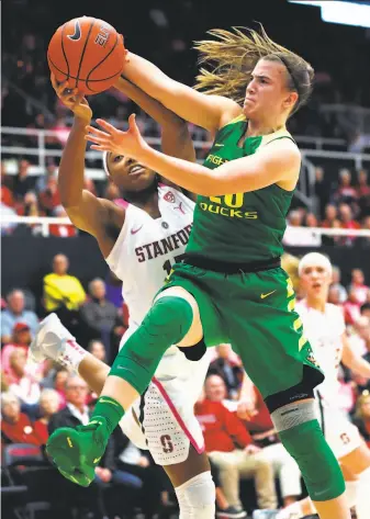  ?? Scott Strazzante / The Chronicle ?? Oregon’s Sabrina Ionescu outrebound­s Stanford’s Maya Dodson during the second quarter of the Ducks’ 88-48 rout at Maples Pavilion. It was the Cardinal’s worst home loss since 1983.