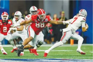  ?? JASON GETZ / JASON.GETZ@AJC.COM ?? Ohio State quarterbac­k C.J. Stroud (7) eludes the pressure from Georgia defensive lineman Jalen Carter (88) on Dec. 31 during the first half in the Peach Bowl Playoff Semifinal at Mercedes-Benz Stadium in Atlanta. Georgia won 42-41.