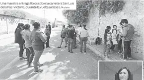  ??  ?? Una maestra entrega libros sobre la carretera San Luis de la Paz-Victoria, durante la vuelta a clases./Archivo