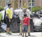  ?? WALSH / ASSOCIATED PRESS ?? President Barack Obama talks with Jacolson Kelley, 6, as Marlette Sanders watches at left, while touring Baton Rouge, La., on Tuesday.SUSAN