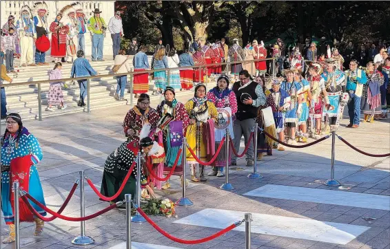  ?? (AP/Indian Country Today/Jourdan Bennett-Begaye) ?? Crow Nation citizens and representa­tives, including students from Plenty Coups High School, lay flowers Tuesday at the front of the Tomb of the Unknown Soldier Plaza for a centennial commemorat­ion in Arlington, Va.