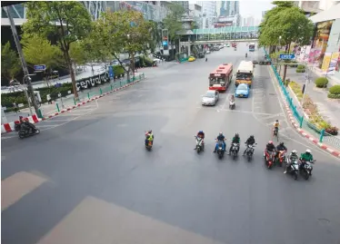  ?? PORNPROM SATRABHAYA ?? Traffic is unusually light at Ratchapras­ong intersecti­on, one of the busiest in downtown Bangkok, as more offices adopt a work-from-home policy amid the ongoing Covid-19 outbreak.