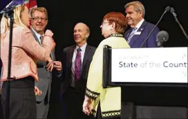  ?? EMILY HANEY / EMILY.HANEY@AJC.COM ?? Gwinnett Commission Chairman Charlotte Nash chats at the podium with other officials after her state of the county address at the Infinite Energy Forum in Duluth. Nash has touted the county’s pending contract with MARTA and the plan that would guide transit expansion if the referendum passes.