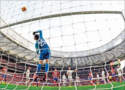  ?? GABRIEL BOUYS/AFP ?? Real Madrid’s Belgian goalkeeper Thibaut Courtois jumps to block a shot on goal during the Spanish league football match between Club Atletico de Madrid and Real Madrid CF at the Wanda Metropolit­ano stadium in Madrid on Saturday.