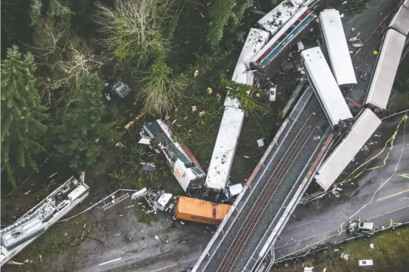  ?? BETTINA HANSEN/THE SEATTLE TIMES VIA AP ?? Cars from an Amtrak train that derailed above spilled onto Interstate 5, Monday, Dec. 18, 2017, in DuPont, Wash. The Amtrak train making the first-ever run along a faster new route hurtled off the overpass Monday near Tacoma and spilled some of its...