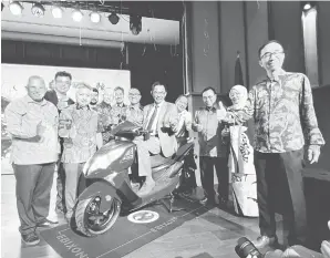  ?? — Gambar Roystein Emmor ?? MESRA ALAM: Karim menunggang salah satu model motosikal elektrik EBIXON pada pelancaran­nya di Muzium Budaya Borneo semalam. Turut kelihatan dua Timbalanny­a Datuk Sebastian Ting (tiga kiri) dan Datuk Snowdan Lawan (dua kiri).
