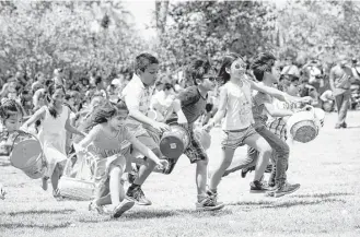  ?? Brett Coomer / Houston Chronicle ?? Children race along the grass to hunt Easter eggs during the annual Easter in the Gardens at Moody Gardens in Galveston. Some of the young participan­ts had an egg-gathering strategy.