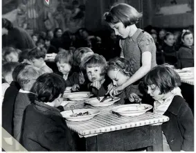  ??  ?? ABOVE Eileen Meakin, aged 13, with some of her little charges at a children’s feeding centre, in Hoxton, north London. June 1942