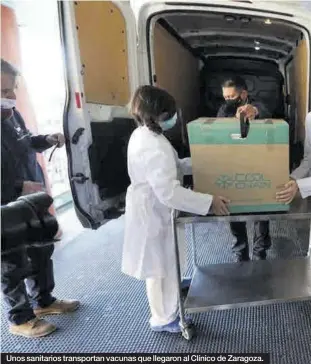  ??  ?? Unos sanitarios transporta­n vacunas que llegaron al Clínico de Zaragoza.