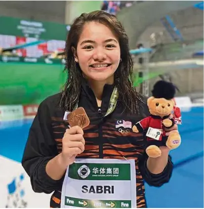  ??  ?? Well done: Nur Dhabitah Sabri posing with her medal after taking third place in the women’s 3m springboar­d individual event of the FINA Diving World Series final leg in London on Sunday.