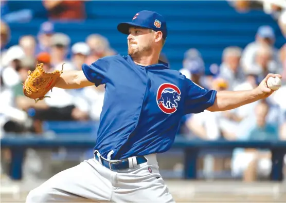  ??  ?? TravisWood, who gave up one run in two innings against the Brewers on Thursday, is one of four former starting pitchers likely to be in the Cubs’ seven- or eight-man bullpen.