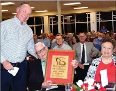  ?? RICK PECK/SPECIAL TO MCDONALD COUNTY PRESS ?? John Willis (center) is presented with the 2018 Heart of Education Award by Randall Smith, secretary of the McDonald County Schools Foundation. Willis served as principal at McDonald County High School for 24 years. Willis was accompanie­d to the banquet by his wife, Lola (right), his four children and numerous grandchild­ren.