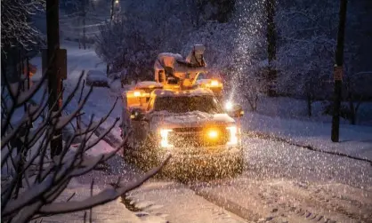  ??  ?? A Duke Energy crew works to restore power in Raleigh, North Carolina, as snow continues to fall on Sunday morning. Photograph: Travis Long /AP